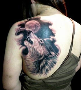 Black wolf and moon tattoo on shoulder