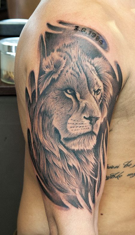 Black words and lion tattoo on leg