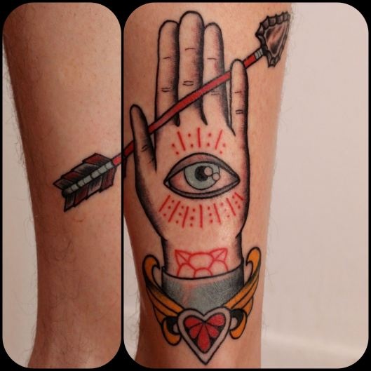 Blue and red palm eye tattoo on leg