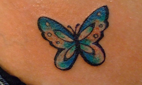 Blue butterfly tattoo on shoulder