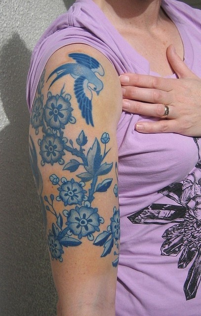 Blue flowers and birds tattoo on arm