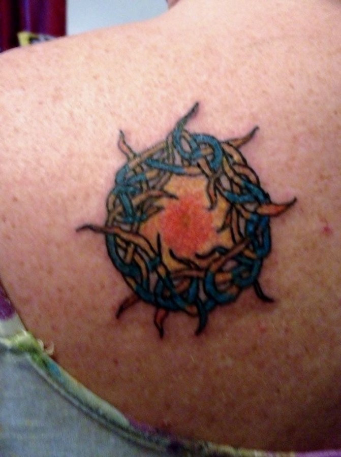 Blue, red sun tattoo on shoulder