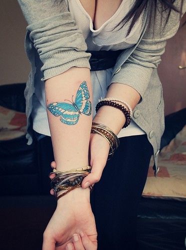 Blue simple butterfly tattoo on arm