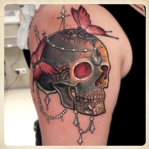 Butterflies and green skull tattoo on shoulder