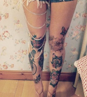 Cat, bike and red rose tattoo on leg