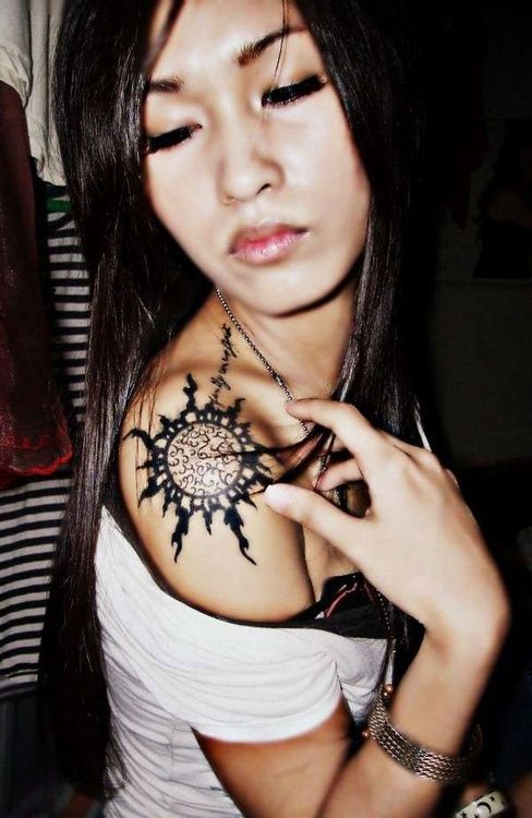 Chinese girl’s sun tattoo on shoulder