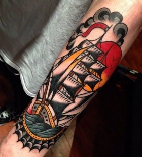 Colorful black ship tattoo on arm