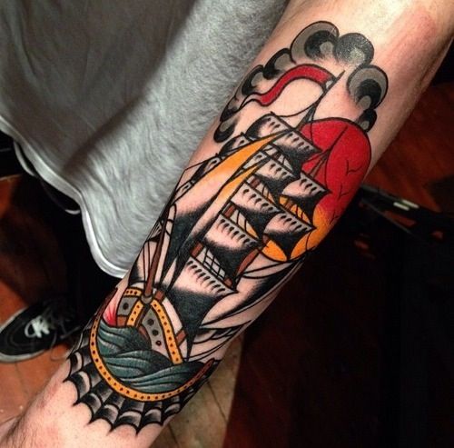 Colorful black ship tattoo on arm