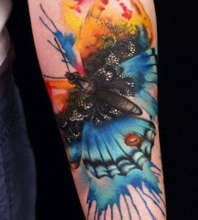 Colorful butterfly and lace tattoo on arm