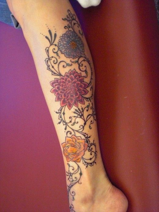 Colorful lovely flower tattoo on leg