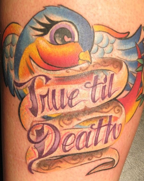 Colorful parrot and quote tattoo on leg