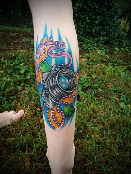 Colorful purple camera tattoo on leg