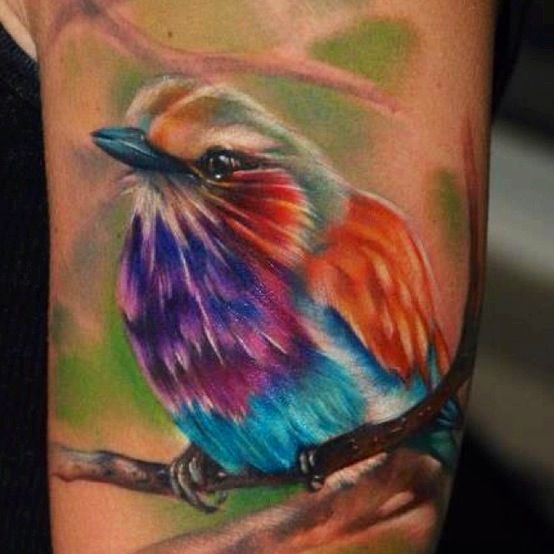 Colorful simple bird tattoo on arm