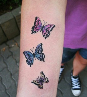 Colorful small butterfly tattoo on arm