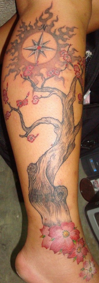 Compass and simple tree tattoo on leg