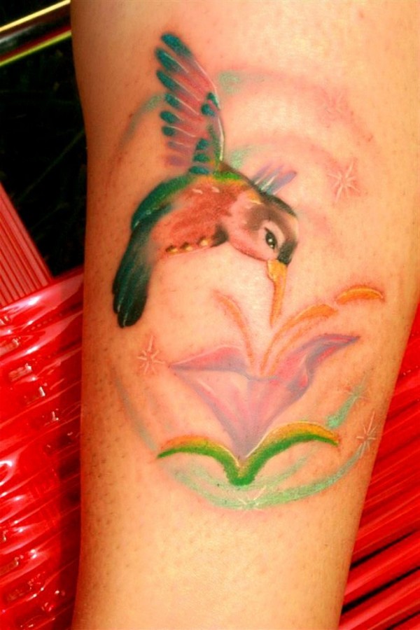 Cute colorful bird tattoo on leg