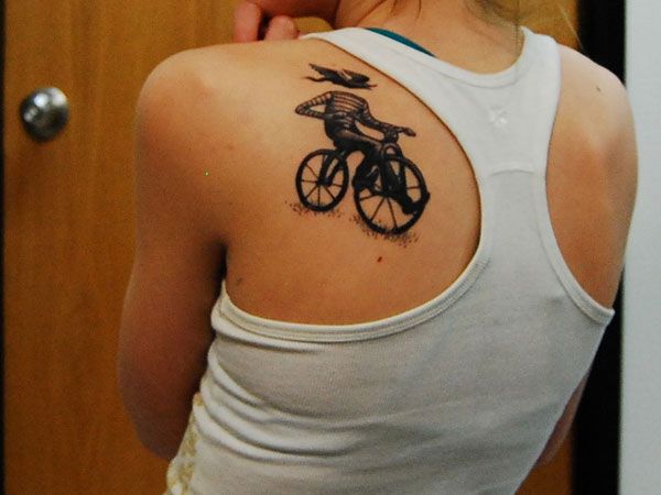 Cute girl’s bicycle tattoo on back