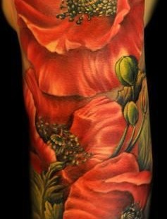 Cute red poppy tattoo on arm