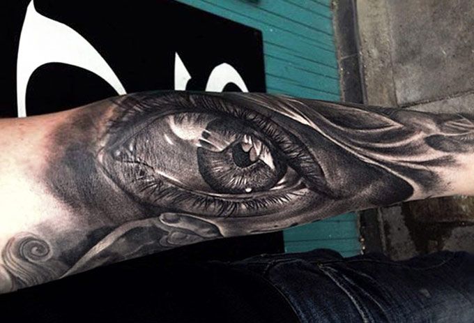 Deep black eye tattoo on arm