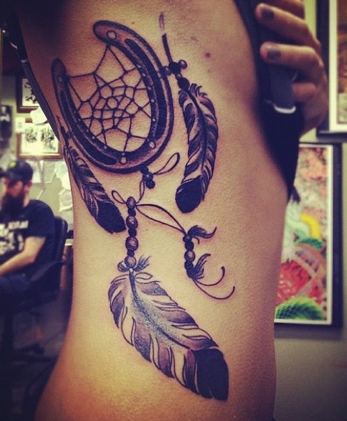 Feather and black horse shoe tattoo