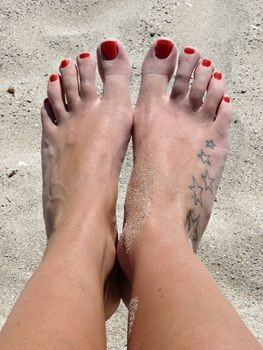 Foot and sand star tattoo on leg