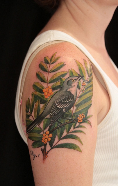 Green leaf and bird tattoo