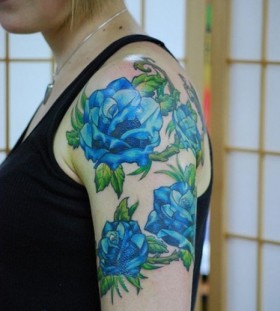 Green leafs and rose blue flowers tattoos