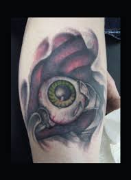 Green owal eye tattoo on leg