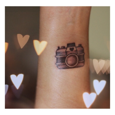 Lovely heart and camera tattoo on arm