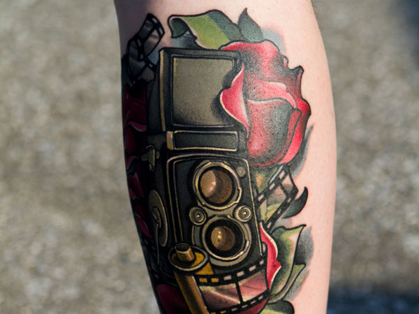 Magical red rose and camera tattoo on leg