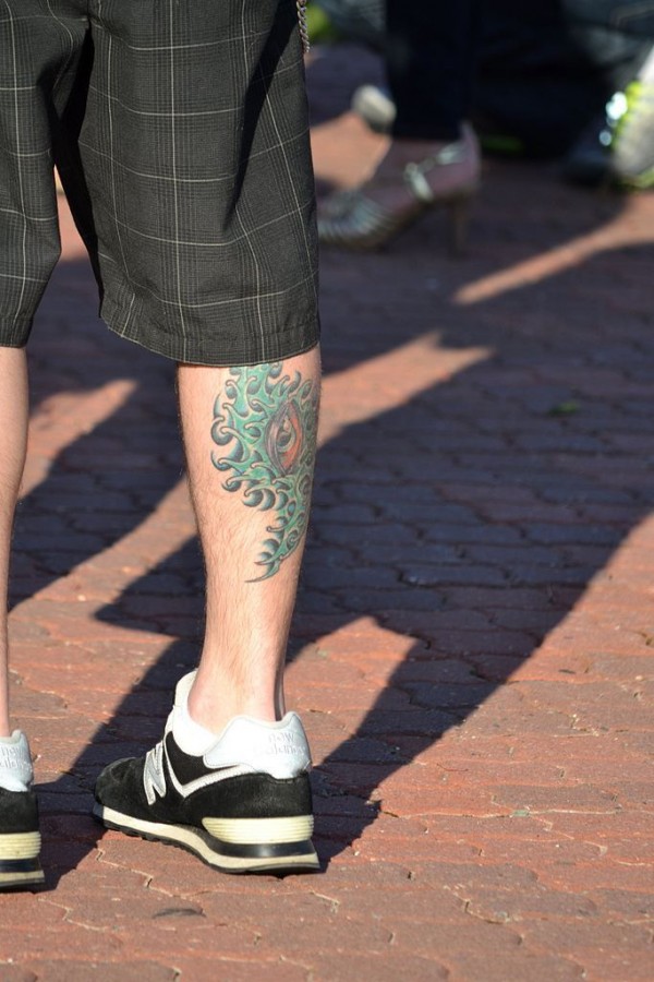 Men’s green eye tattoo on leg