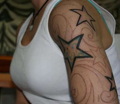 Ornaments and simple star tattoo on arm