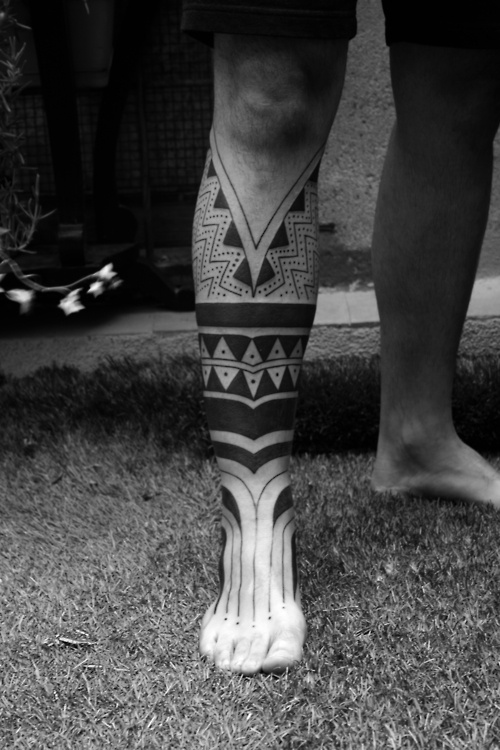 Ornaments of black tribal tattoo on leg