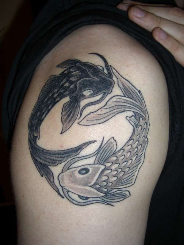 Owal of black fish tattoo on arm