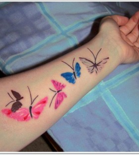 Pink and blue butterfly tattoo on arm