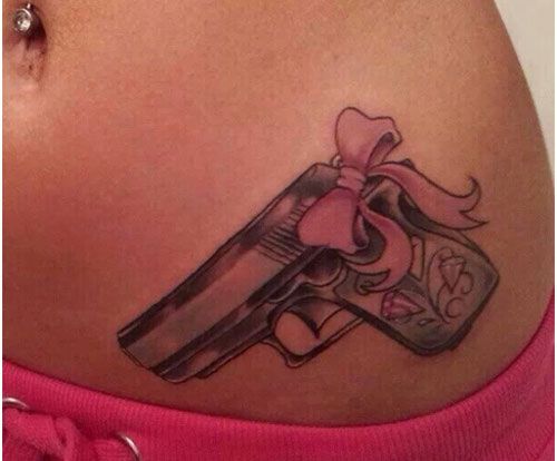 Pink bow and gun tattoo