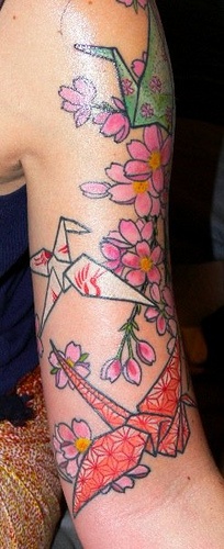 Pink flowers and origami tattoo on arm