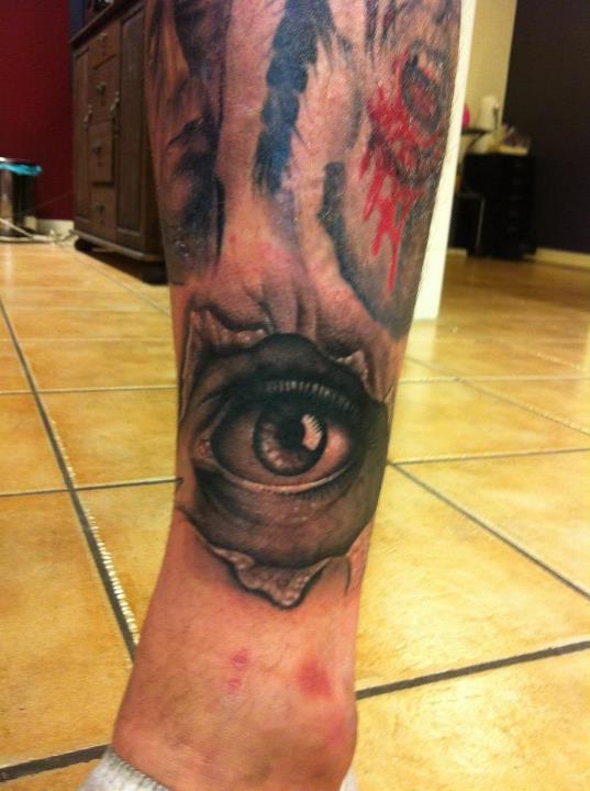 Pretty black and red eye tattoo on leg