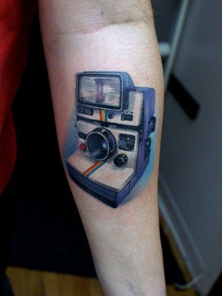 Pretty blue camera tattoo on arm