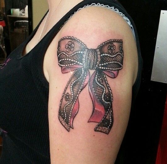 Pretty bow and lace tattoo on arm