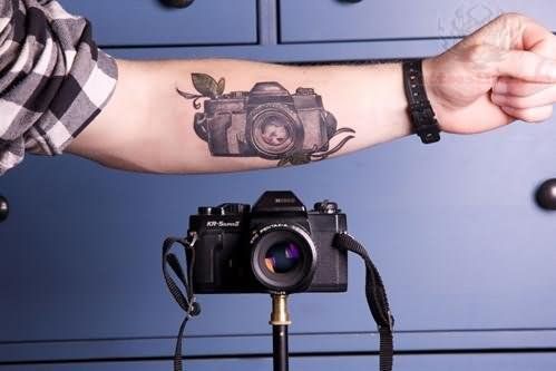 Realistic black camera tattoo on arm