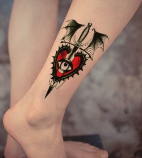 Red and black heart with eye tattoo on leg