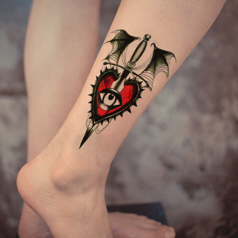 Red and black heart with eye tattoo on leg