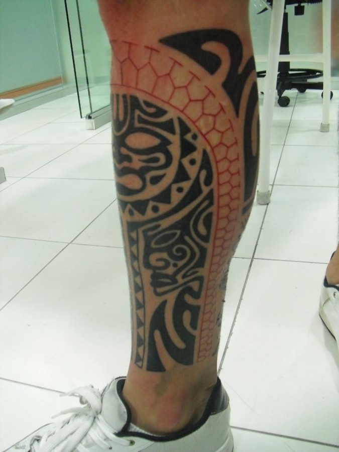 Red and black sun tattoo on leg