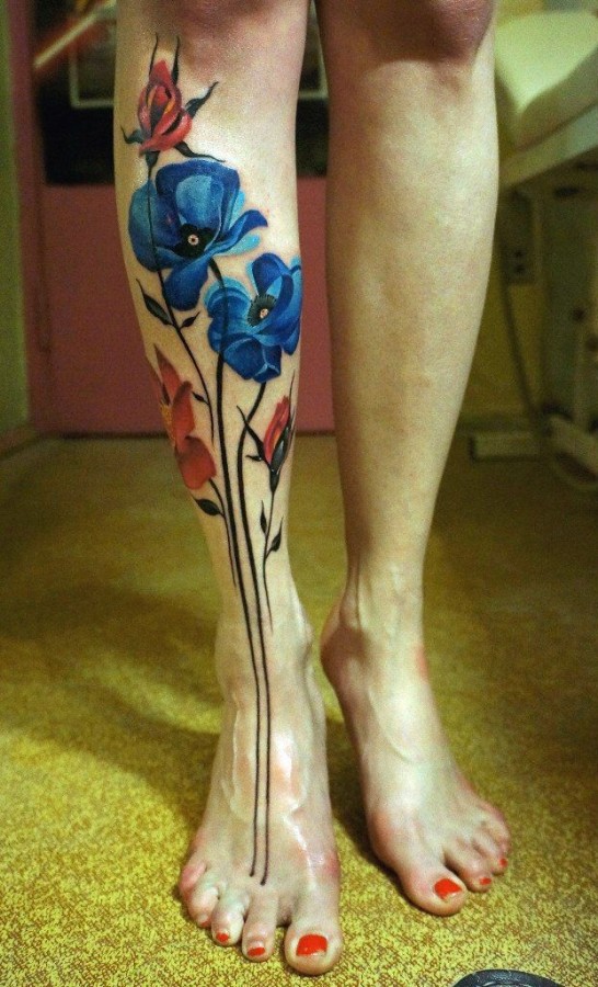 Red and blue poppy tattoo on leg