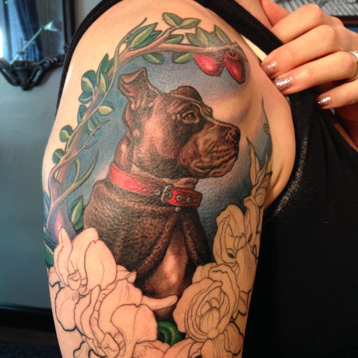 Red cherries, green leafs and dog tattoo on arm