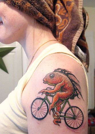 Red fish and bicycle tattoo on arm