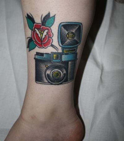 Red flower and camera tattoo on leg