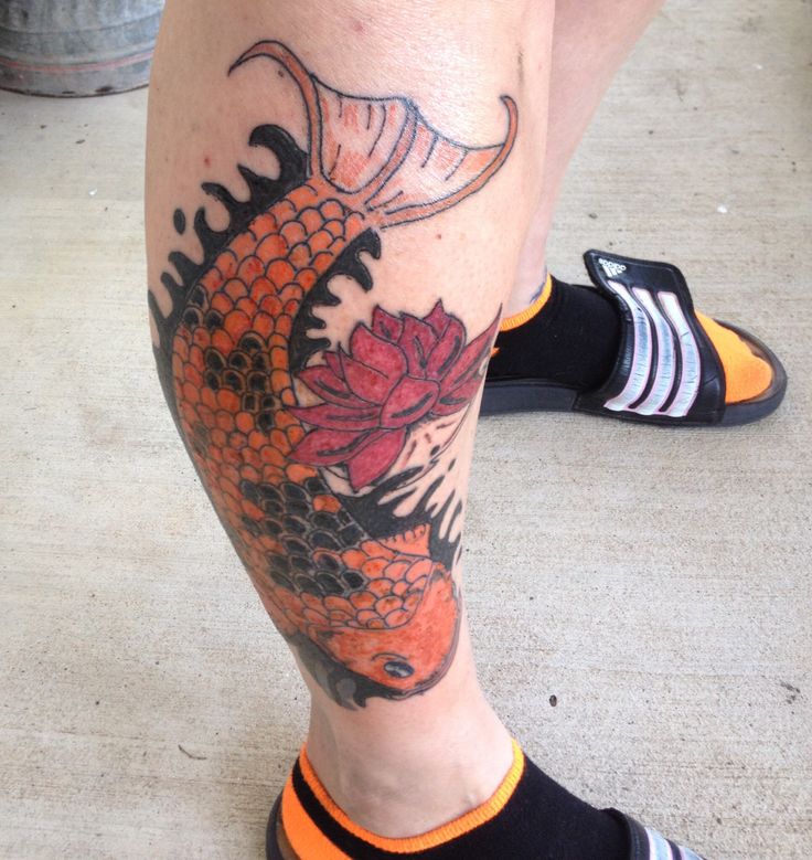 Red flower and orange fish tattoo on leg