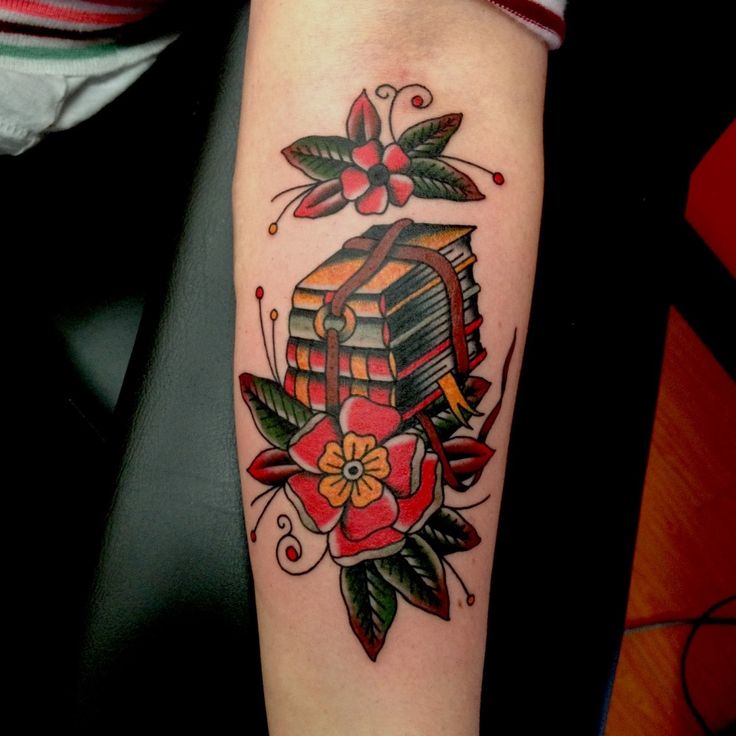 Red flowers and book tattoo on arm